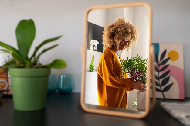 Primo piano su una donna che decora la sua casa con orchidee