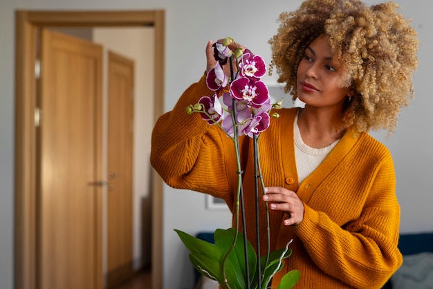 Primo piano su una donna che decora la sua casa con orchidee