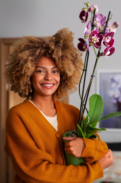 Primo piano su una donna che decora la sua casa con orchidee