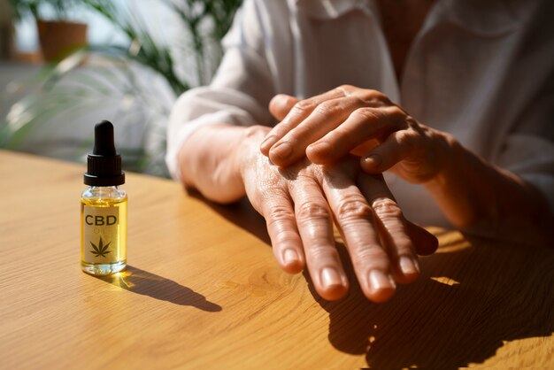 Primo piano su una donna che usa l'olio di CBD a portata di mano