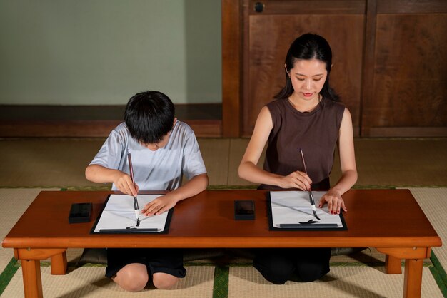 Primo piano sugli alunni che fanno calligrafia giapponese, chiamata shodo