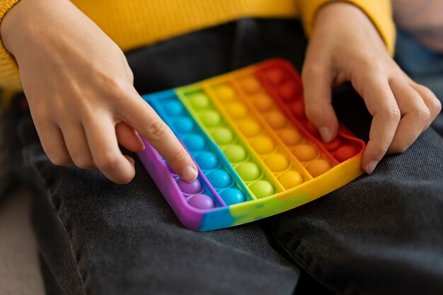 Primo piano sul bambino che gioca con il giocattolo pop it