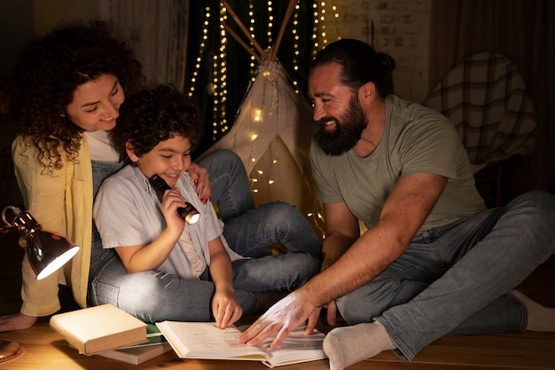 Primo piano sul bambino che legge con i suoi genitori