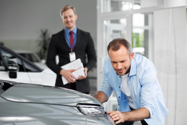 Primo piano sul cliente con un uomo d'affari in una concessionaria d'auto