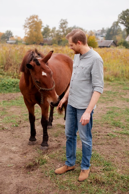 Primo piano sul contadino con un bellissimo cavallo