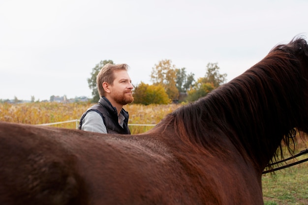 Primo piano sul contadino con un bellissimo cavallo