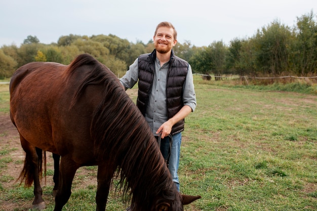 Primo piano sul contadino con un bellissimo cavallo