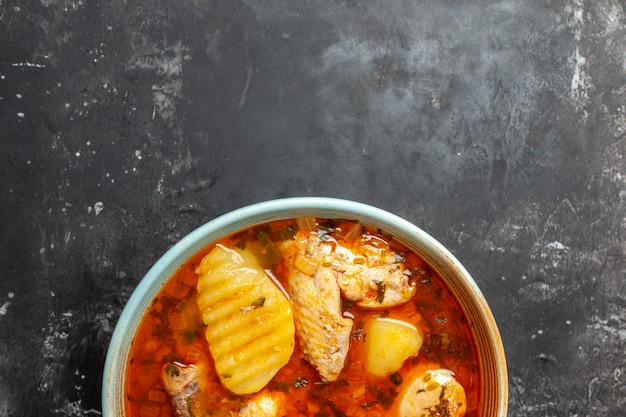 Primo piano sul piatto con zuppa di pollo su sfondo nero