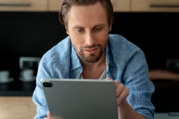 Primo piano sull'uomo che utilizza un dispositivo digitale a casa