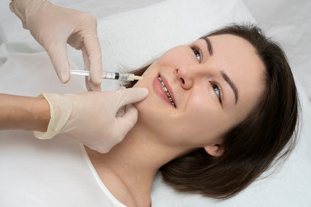 Primo piano sulla donna durante la procedura di riempimento delle labbra