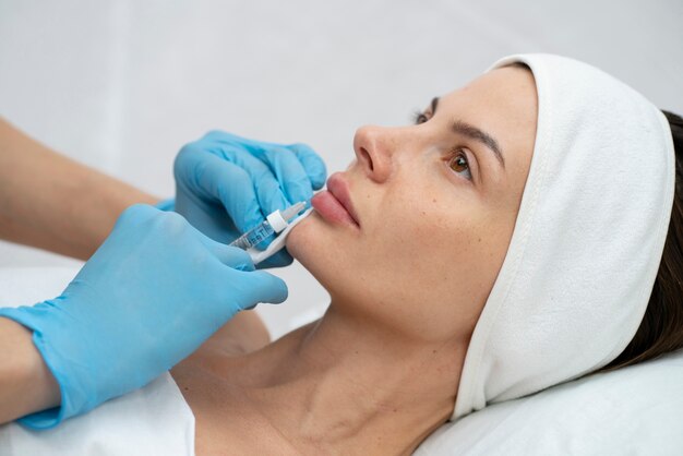 Primo piano sulla donna durante la procedura di riempimento delle labbra