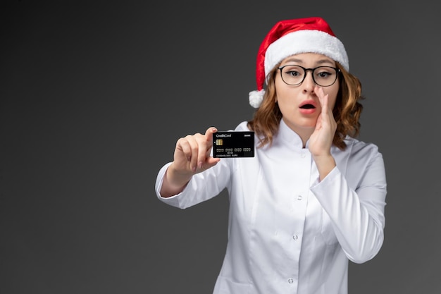 Primo piano sulla giovane donna graziosa che indossa il cappello di Natale isolato