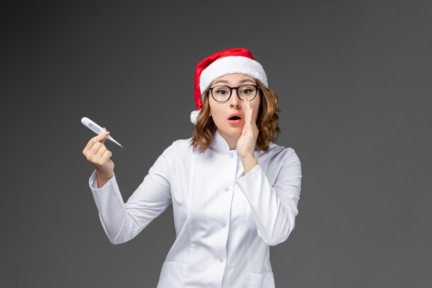 Primo piano sulla giovane donna graziosa che indossa il cappello di Natale isolato