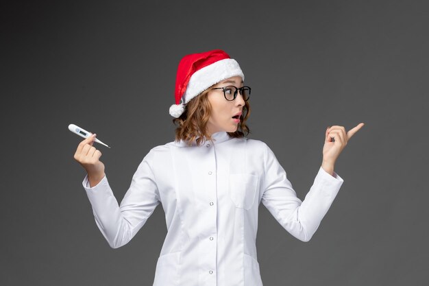 Primo piano sulla giovane donna graziosa che indossa il cappello di Natale isolato