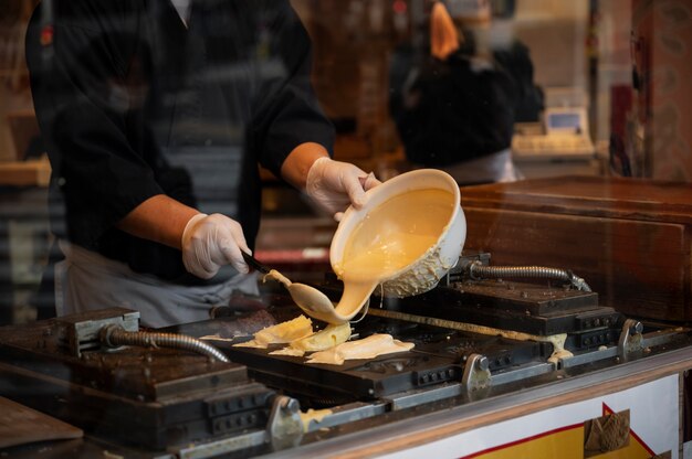 Primo piano sulla persona che cucina cibo di strada giapponese