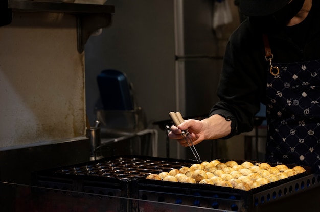 Primo piano sulla persona che cucina cibo di strada giapponese