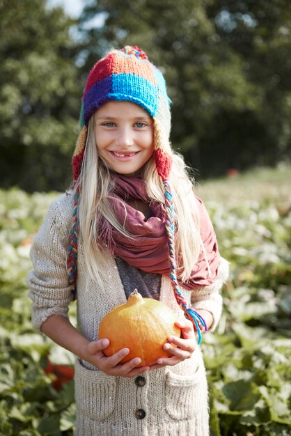 Primo piano sulla ragazza giovane e felice con la zucca