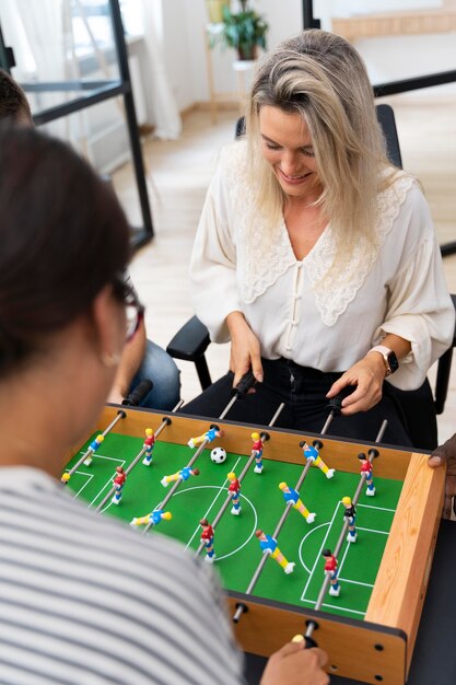 Primo piano sulle persone che si divertono mentre giocano a calcio balilla