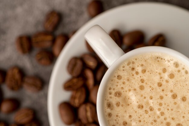 Primo piano tazza di caffè con fagioli arrostiti