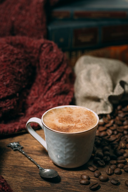 Primo piano tazza di caffè con fagioli arrostiti