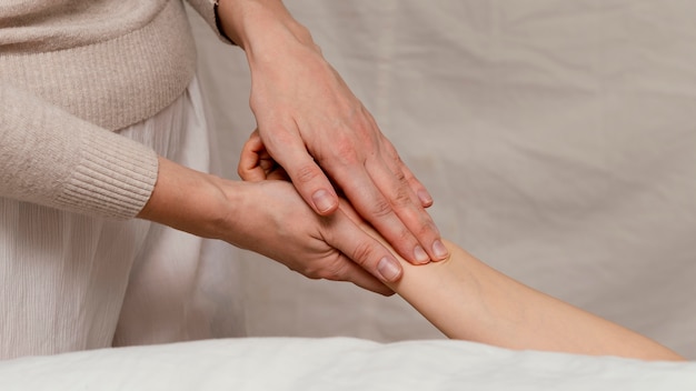 Primo piano terapista che massaggia la mano