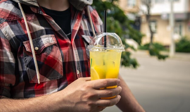 Primo piano un bicchiere di limonata in mani maschili