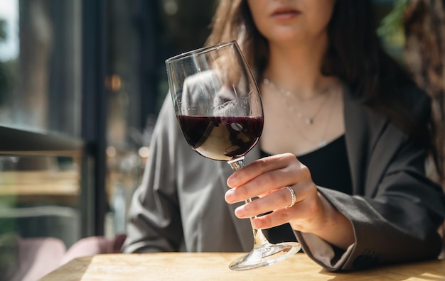 Primo piano un bicchiere di vino in mani femminili in un caffè