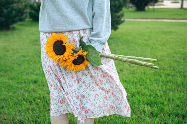 Primo piano un mazzo di girasoli in mani femminili su uno sfondo sfocato