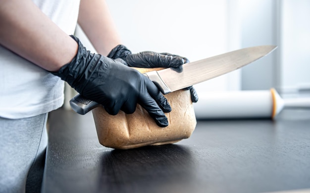 Primo piano un pezzo di pasta nelle mani femminili che lavorano con la pasta