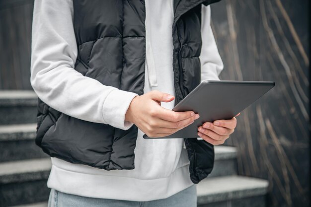 Primo piano una donna sta usando un tablet all'esterno