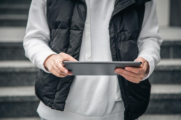 Primo piano una donna sta usando un tablet all'esterno