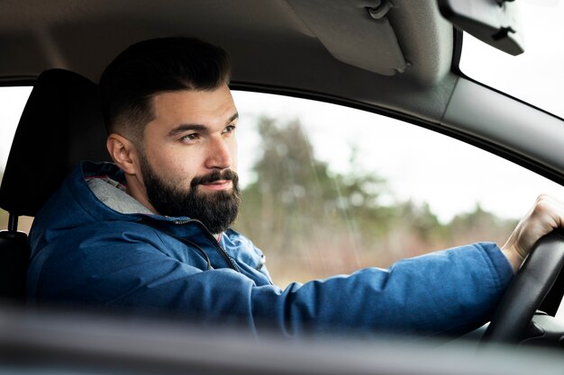 Primo piano uomo alla guida di un'auto