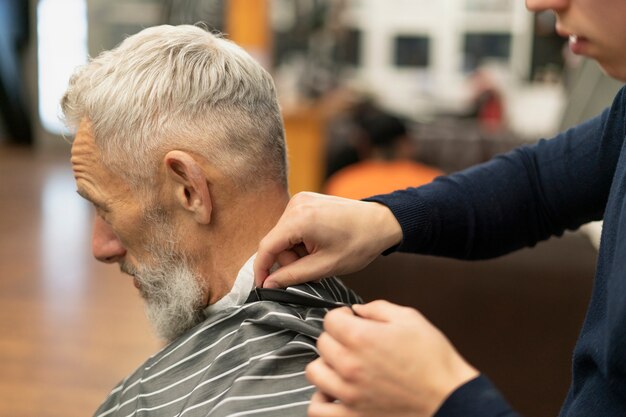Primo piano uomo anziano al negozio di parrucchiere