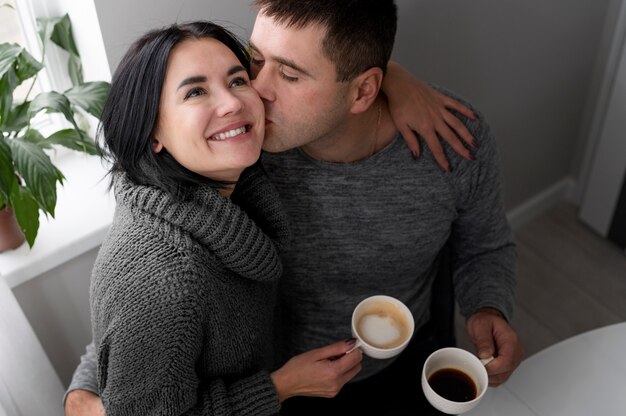 Primo piano uomo che bacia donna sulla guancia