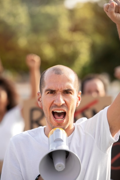 Primo piano uomo che protesta con il megafono