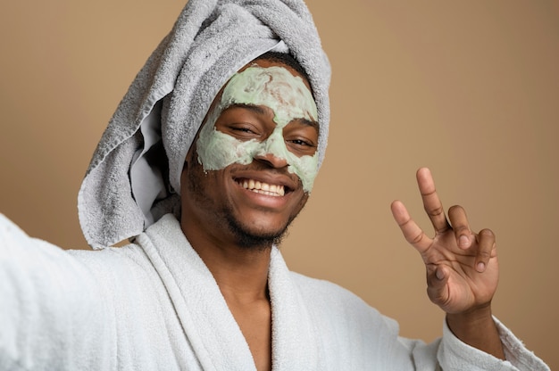 Primo piano uomo sorridente con maschera facciale