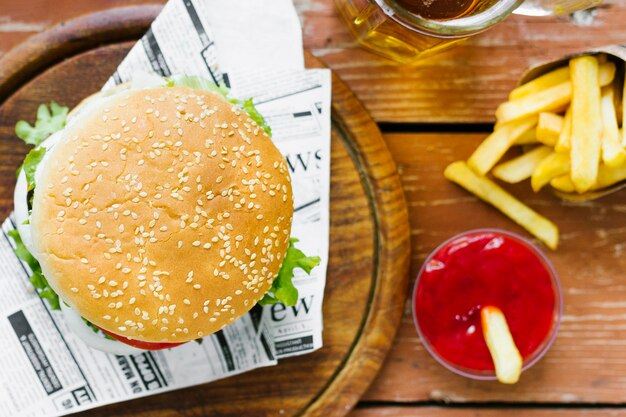 Primo piano vista superiore di hamburger e patatine fritte sul bordo di legno