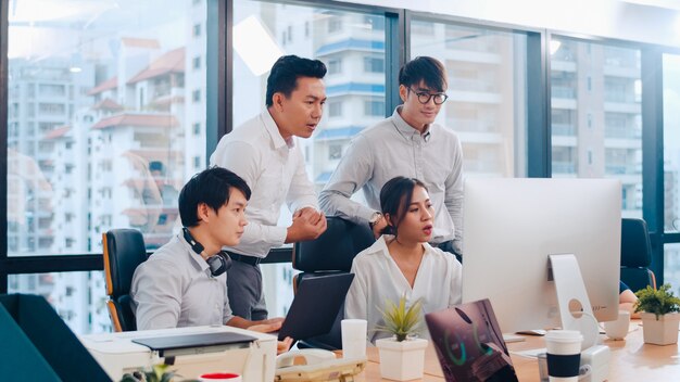 Processo collaborativo di imprenditori multiculturali che utilizzano la presentazione e la comunicazione al computer incontrando idee di brainstorming sulla strategia di successo del piano di lavoro dei colleghi di progetto in ufficio moderno.