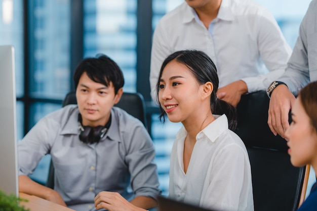 Processo collaborativo di imprenditori multiculturali che utilizzano la presentazione e la comunicazione al computer incontrando idee di brainstorming sulla strategia di successo del piano di lavoro dei colleghi di progetto in ufficio moderno.