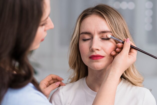 Processo di fare il trucco per la bella donna bionda