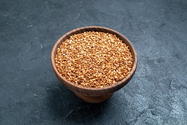 Prodotto utile del grano saraceno crudo di vista frontale all'interno del piatto su spazio scuro