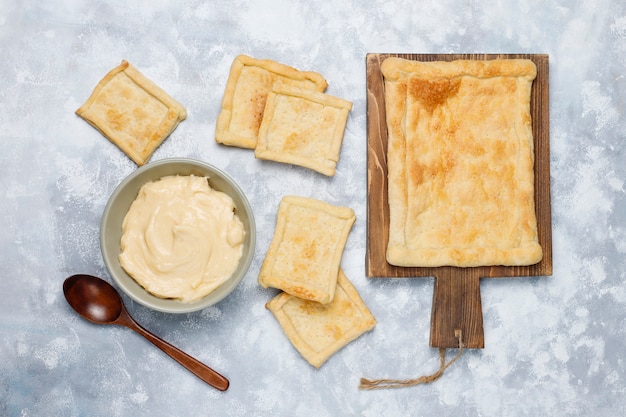 Produrre pasta sfoglia deliziosa fresca con crema pesante su calcestruzzo, vista dall'alto