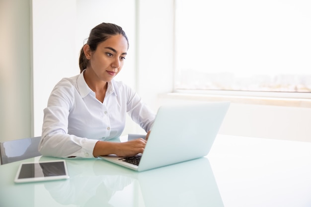 Professionista femminile concentrato che lavora al computer