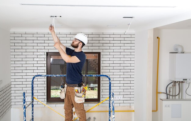 Professionista in tuta con strumenti sullo sfondo del sito di riparazione. Concetto di ristrutturazione della casa.