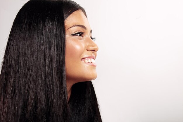 Profilo di donna sorridente felice con i capelli lisci in studio