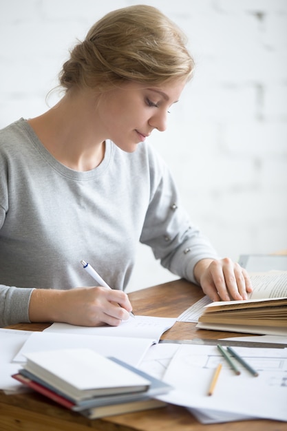 Profilo portait di ragazza che esegue un compito scritto in copybook