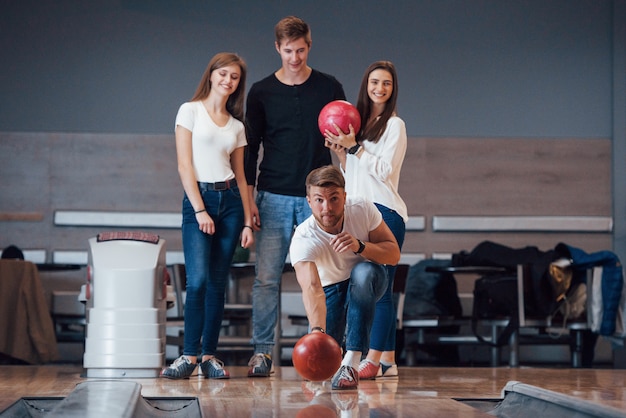 Pronto a lanciare. I giovani amici allegri si divertono al bowling durante i fine settimana