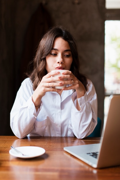 Proprietario femminile della caffetteria che beve caffè