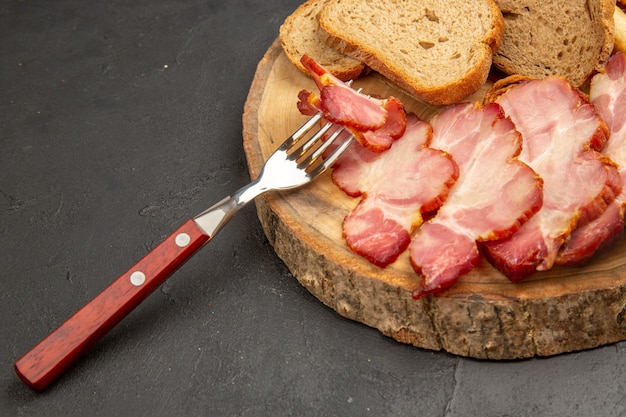 Prosciutto affettato fresco di vista frontale con le fette di pane sul maiale scuro della carne dell'alimento di colore del pasto dello spuntino