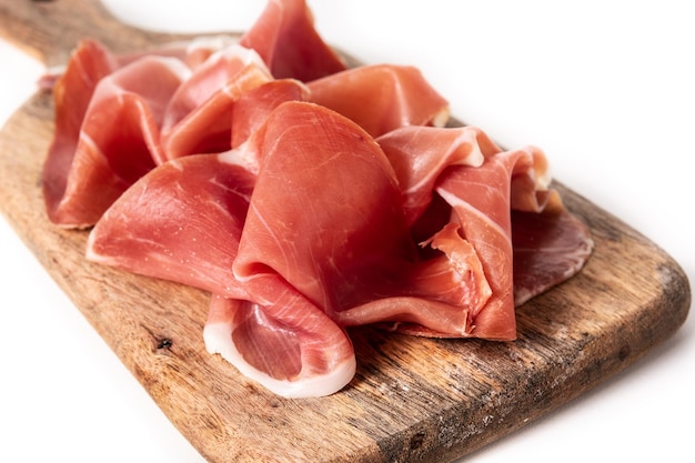 Prosciutto spagnolo serrano sul tagliere isolato su priorità bassa bianca